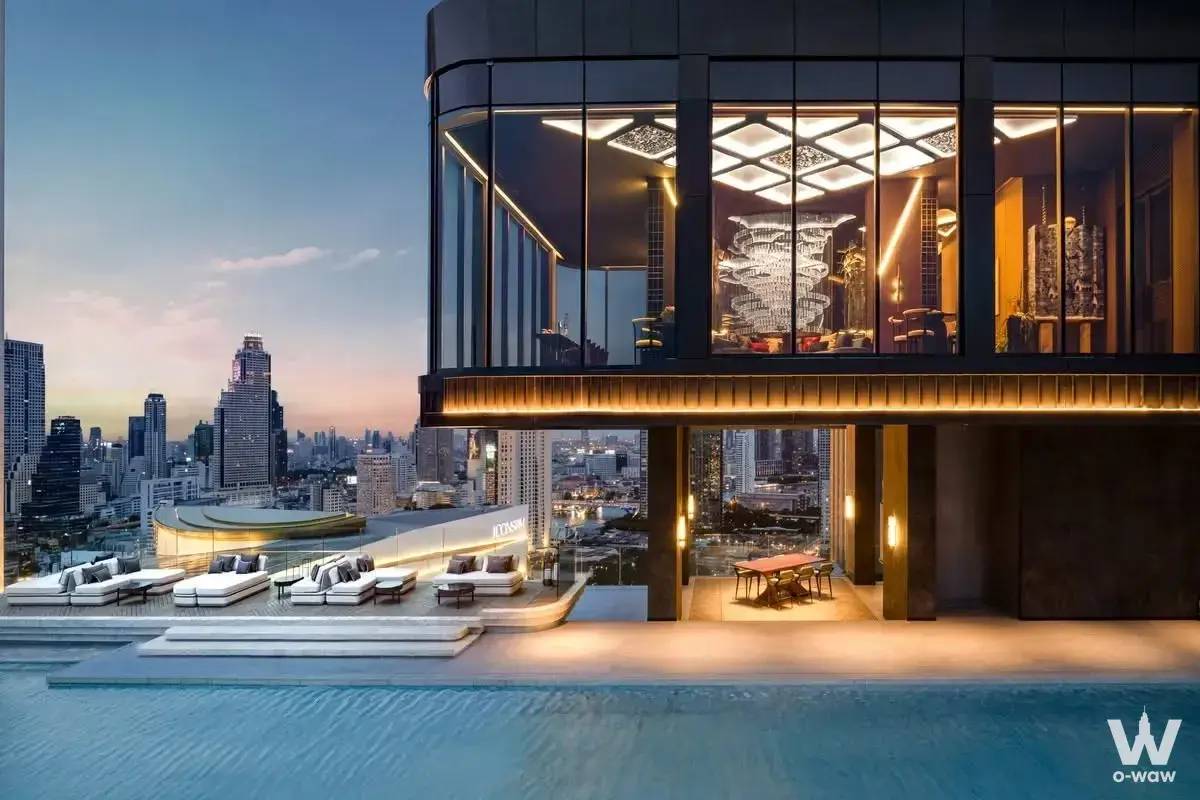 The rooftop infinity pool at this 3-bed condo for sale has sunbeds and a dusk city skyline view