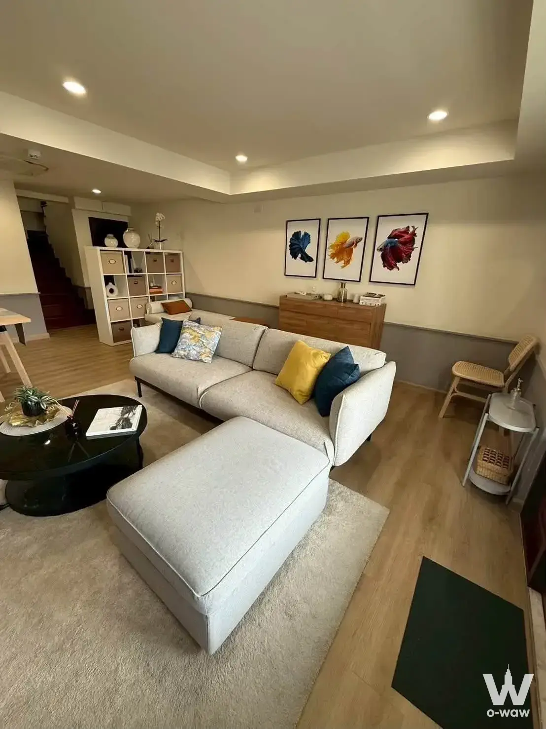 Modern living room in a 2-bed condo for rent at The Old Siam Penthouse with teal accents and wooden stairs