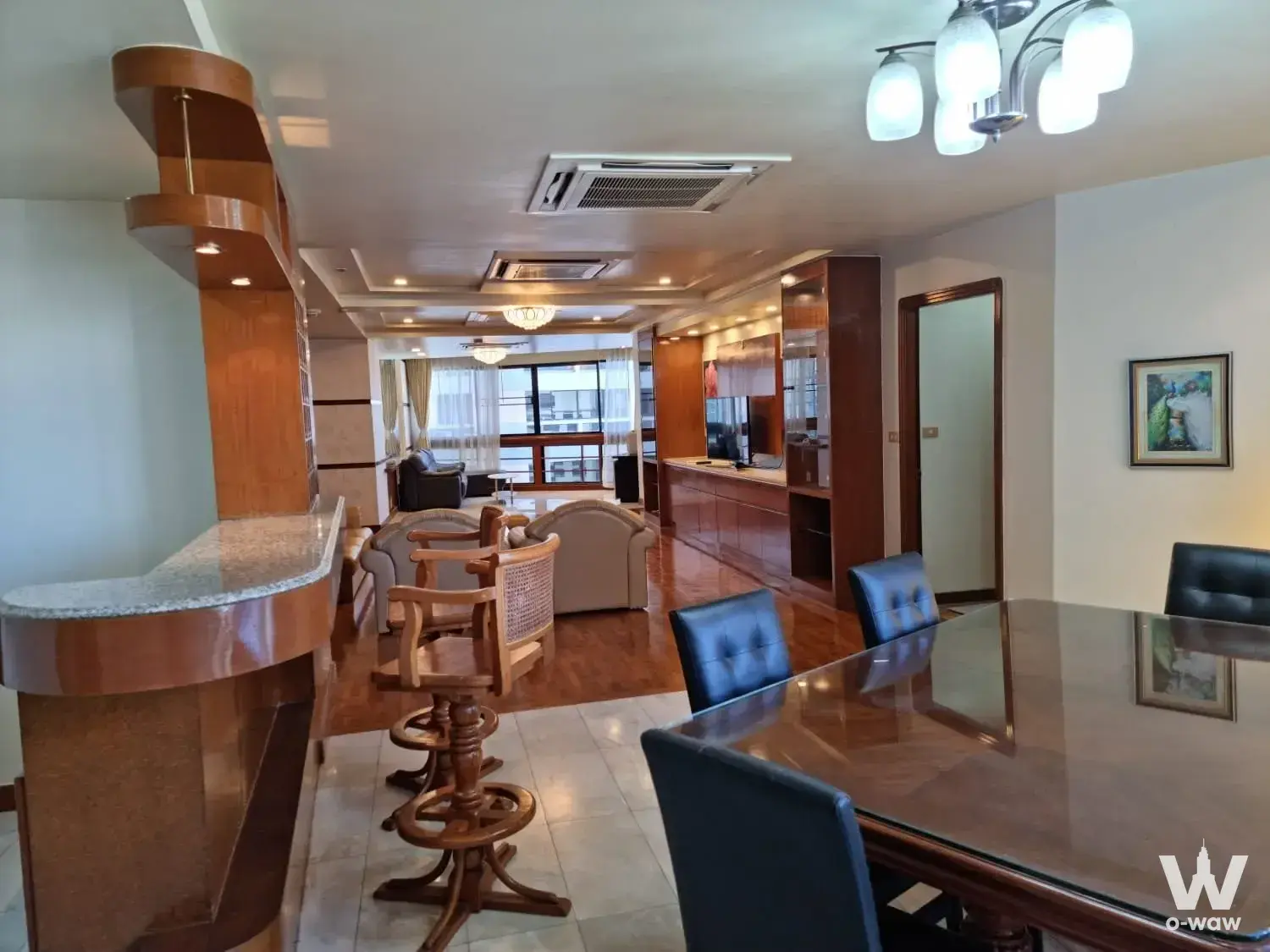Open-plan dining and living area in a 3-bed President Park condo with glass-top table and hardwood floors
