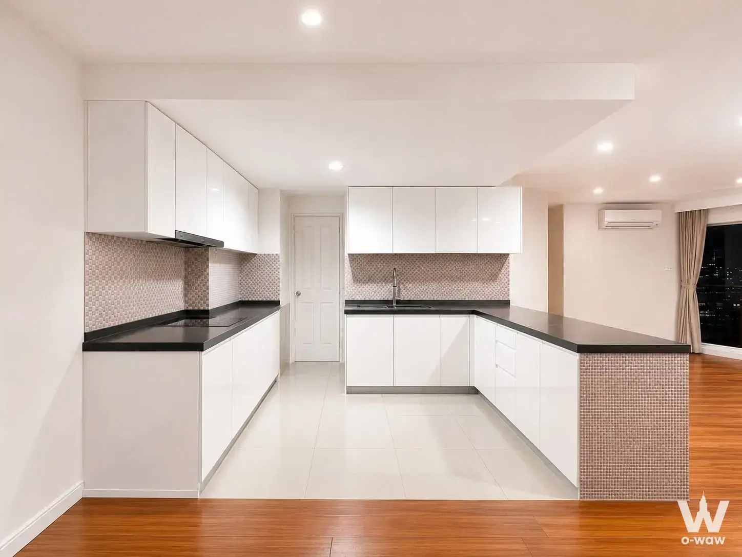 Modern white kitchen with black granite countertops and high-floor city views in Belle Grand Rama 9