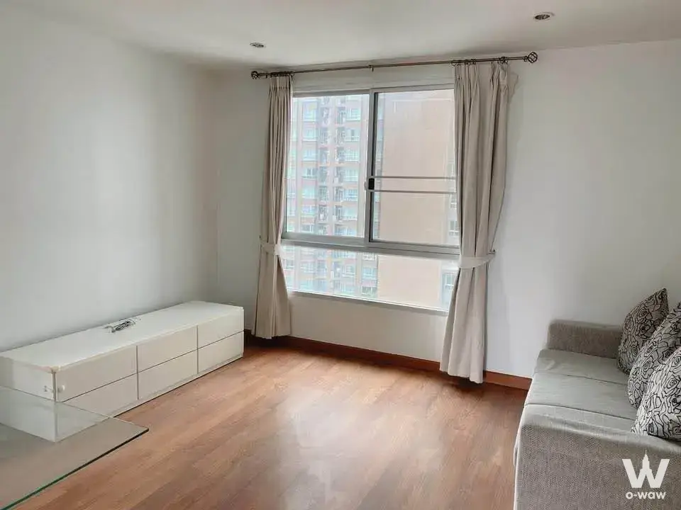 Minimalist living room with grey sofa and white storage cabinet in a 2-bed condo for rent at The Parkland