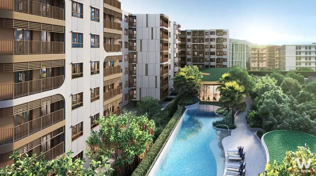 Escent Phuket 1-bed condo exterior featuring curved facade, pool, and lush landscaping