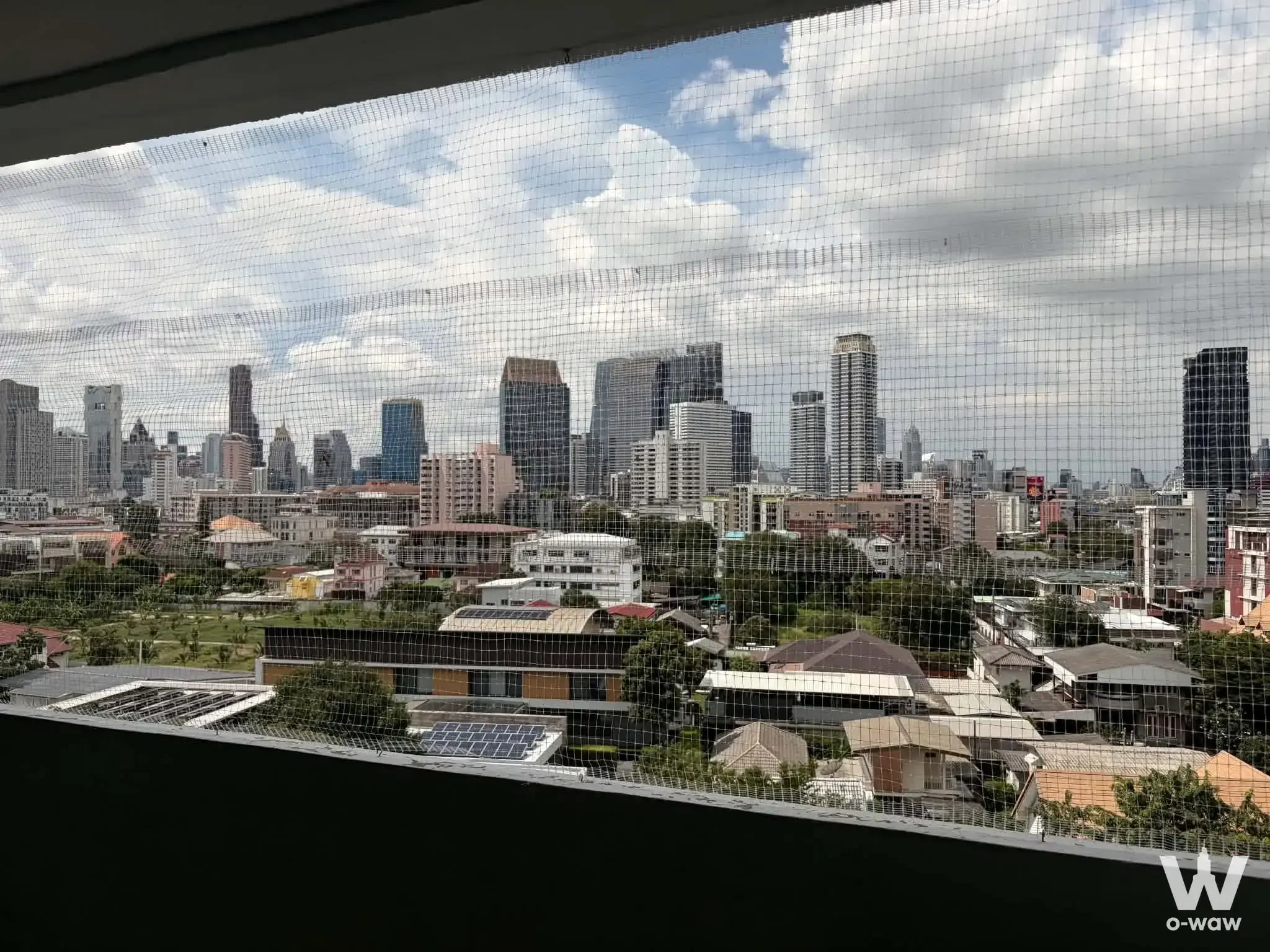Balcony view from a 2-bed The Royal Navin Tower condo with safety netting and a high-floor city skyline