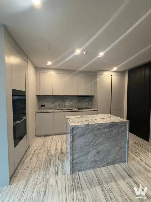 Modern kitchen in a 2-bed Porchland 3 condo with grey marble island and built-in ovens
