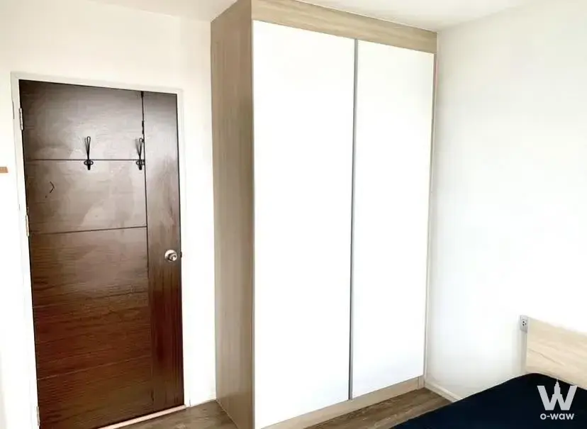 1-bed condo for sale in Episode Phaholyothin-Sapanmai bedroom with white sliding wardrobe doors and dark wood-look flooring