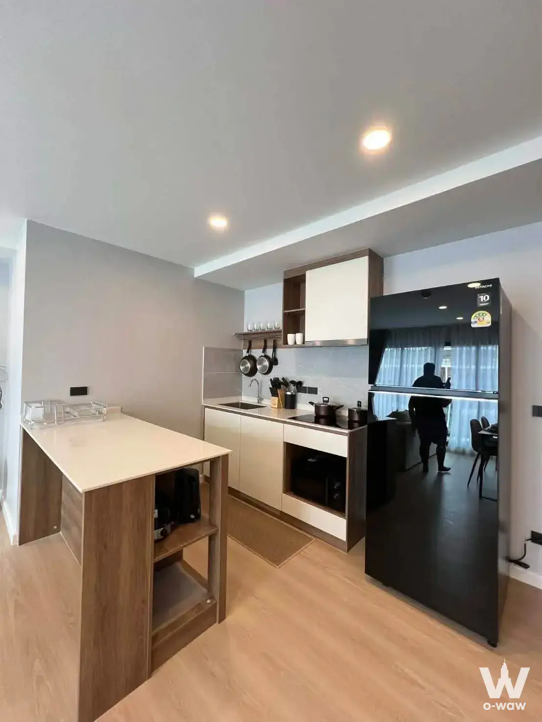 Modern kitchen with wooden island and stainless steel appliances in Space Cherngtalay condo for rent