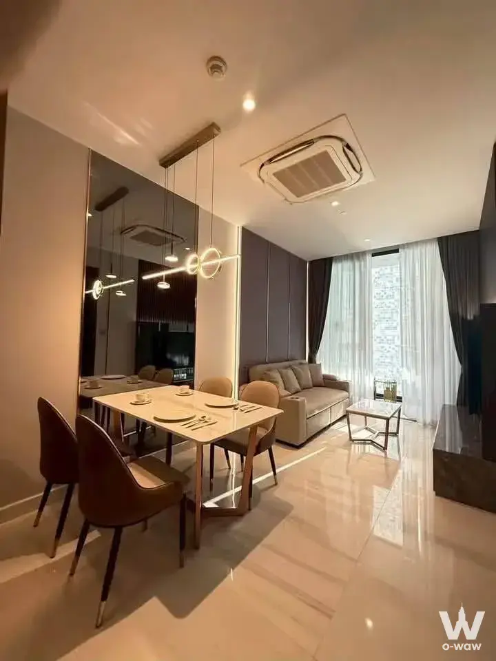 Furnished living room in Supalai Icon Sathorn featuring a marble floor and large mirror accent wall