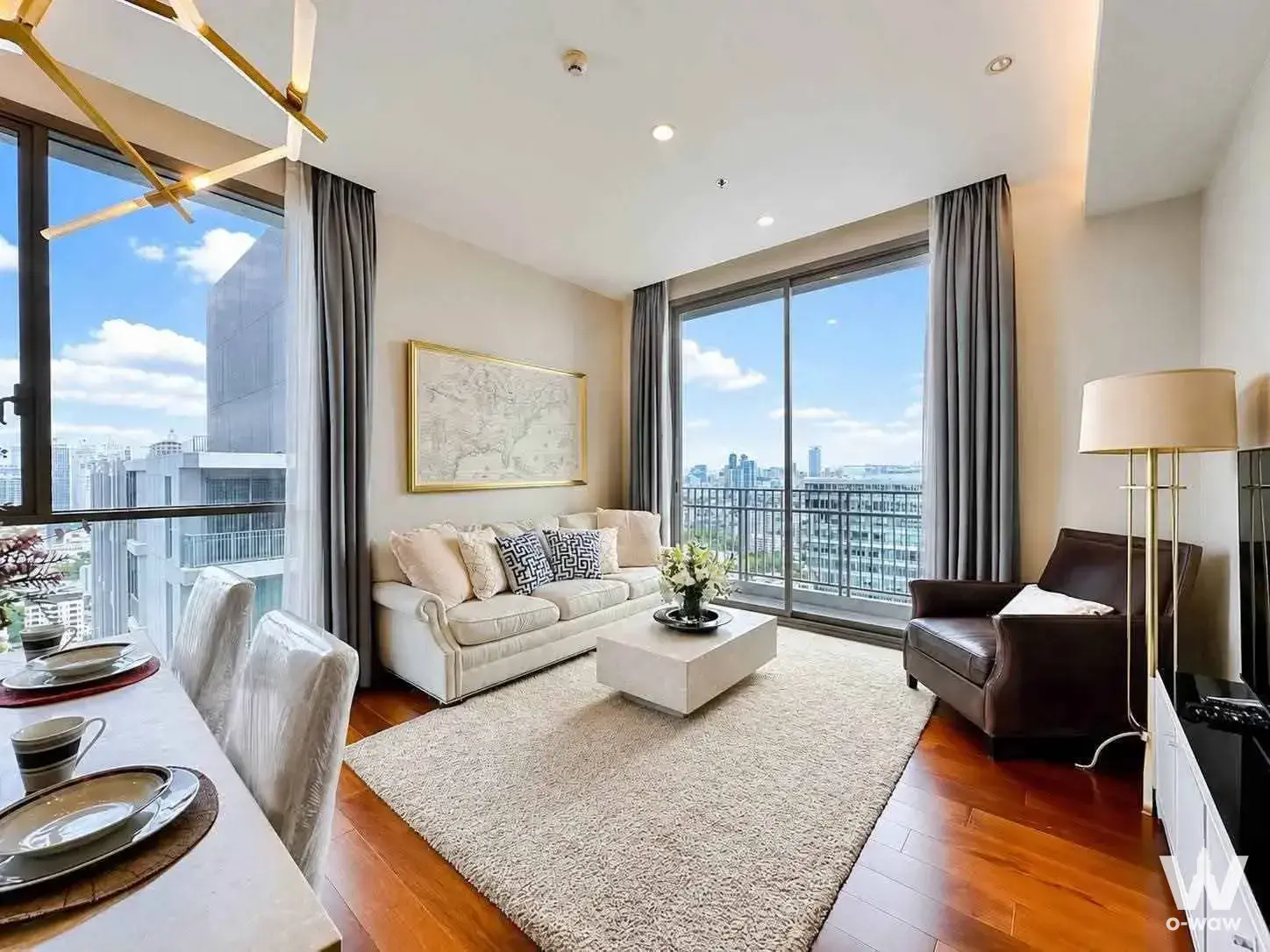 Living room in a 2-bed Quattro condo featuring cream leather seating and a high-floor city skyline view