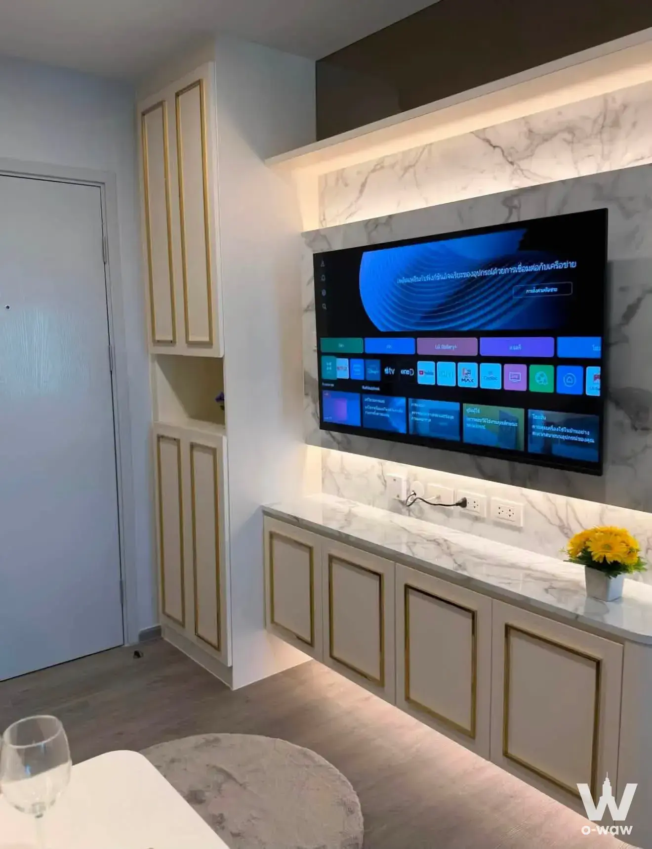 Luxury living room in Regent Home Wutthakat with a marble-vein wall panel, gold-trimmed cabinetry, and warm LED lighting