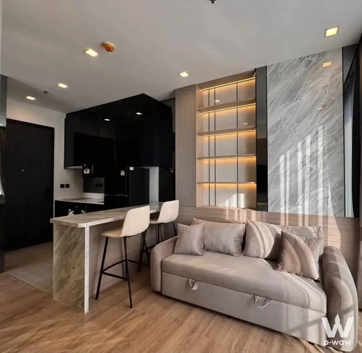 Noble Around Ari 1-bed rental open-plan living area with grey sofa, marble breakfast bar, and modern luxury finishes