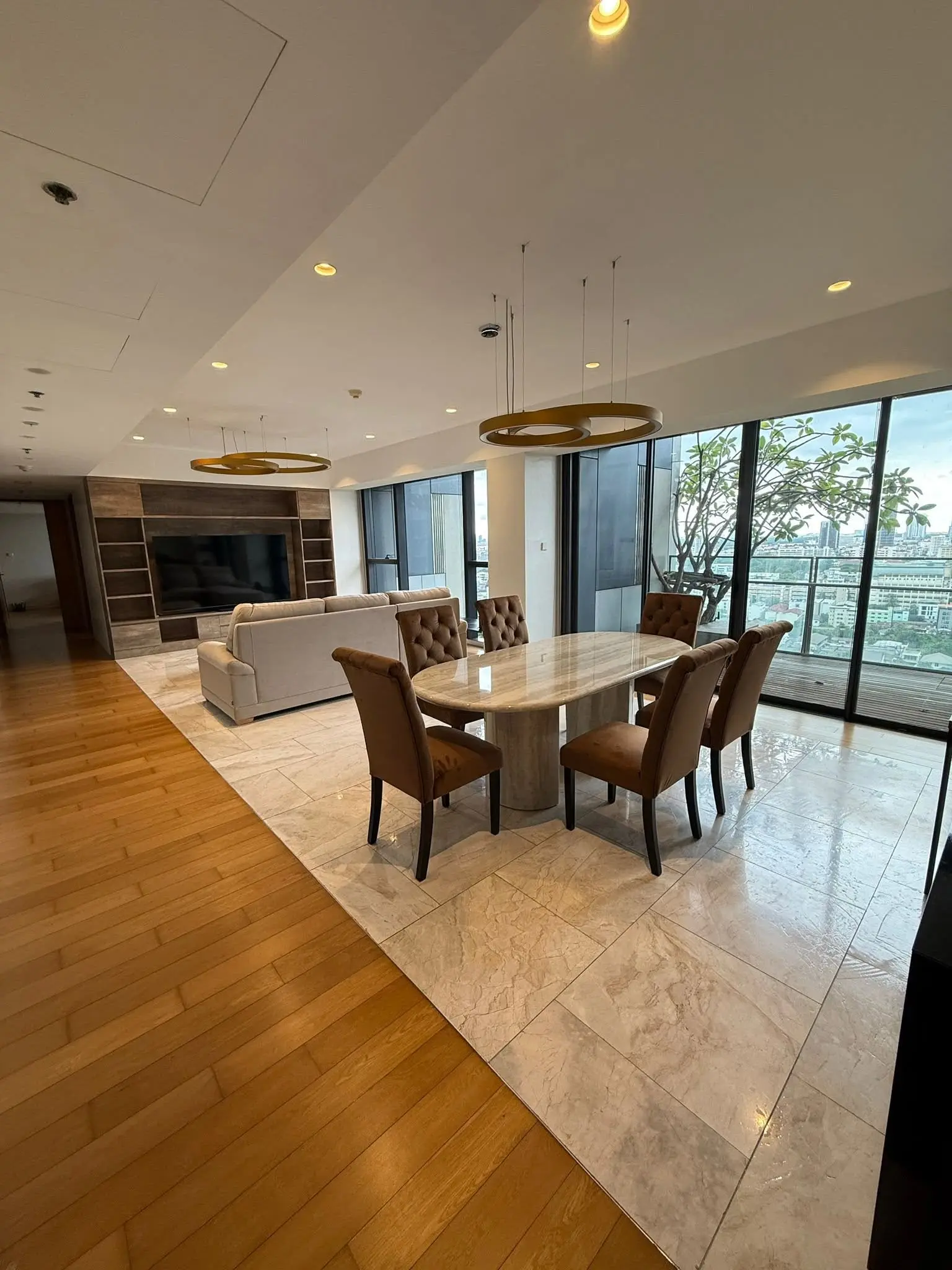 Open-plan living and dining area in a 3-bed The Met condo with marble table and city view