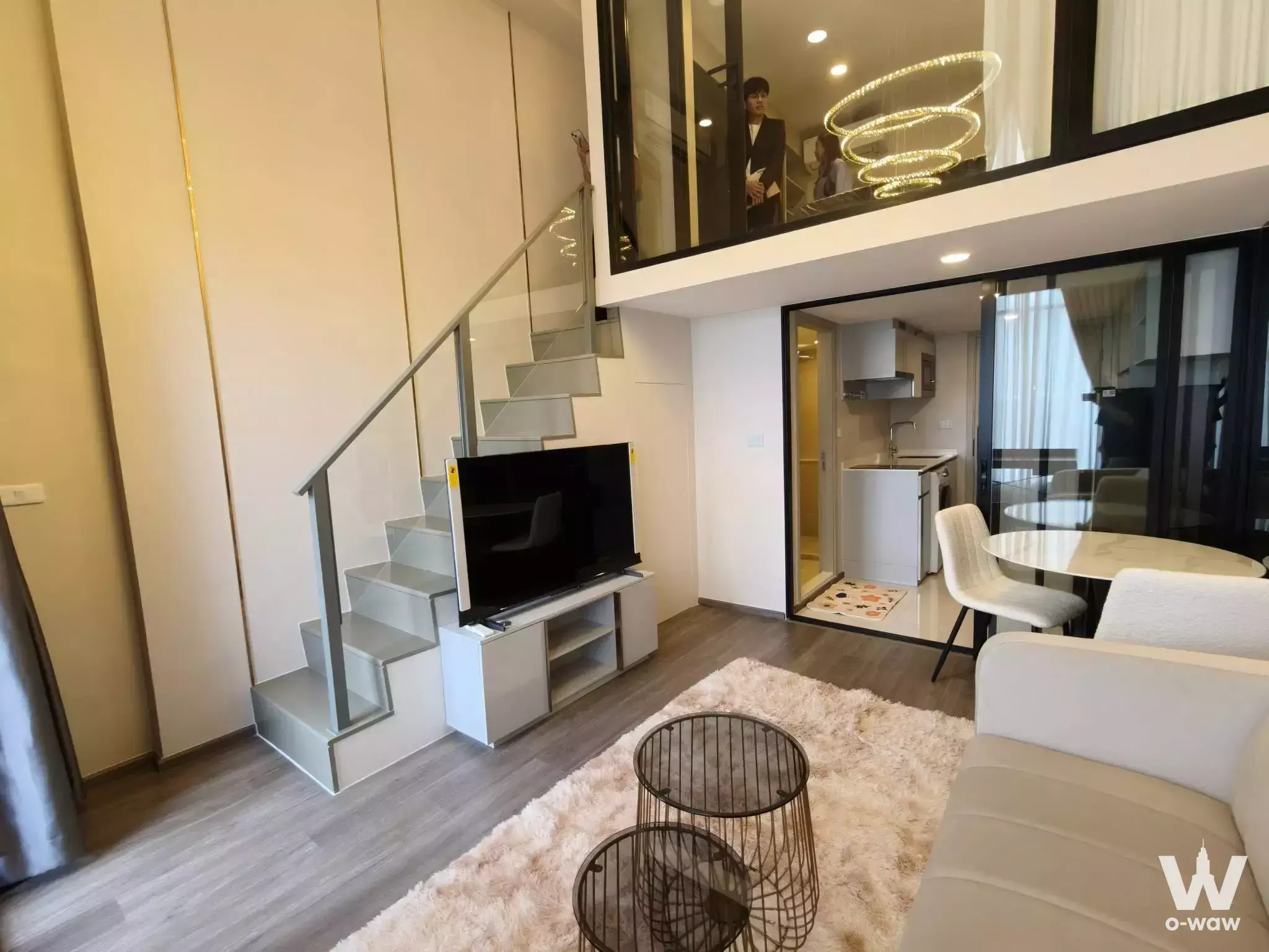 Loft-style living area in So Origin Kaset Interchange with floating staircase and marble dining nook