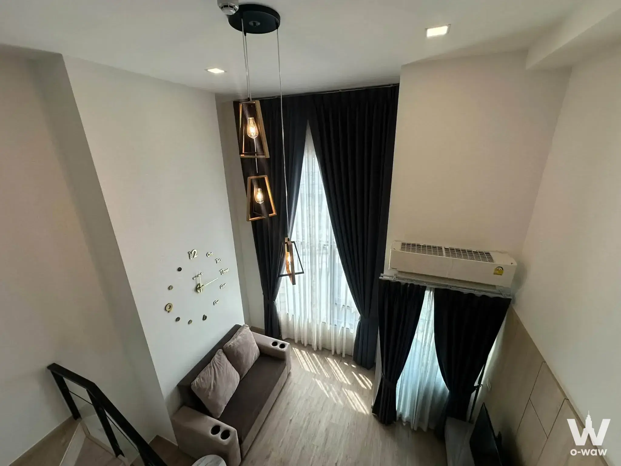 Loft living area with gold pendant lights and blackout drapes at The Rich Rama 9 - Srinakarin