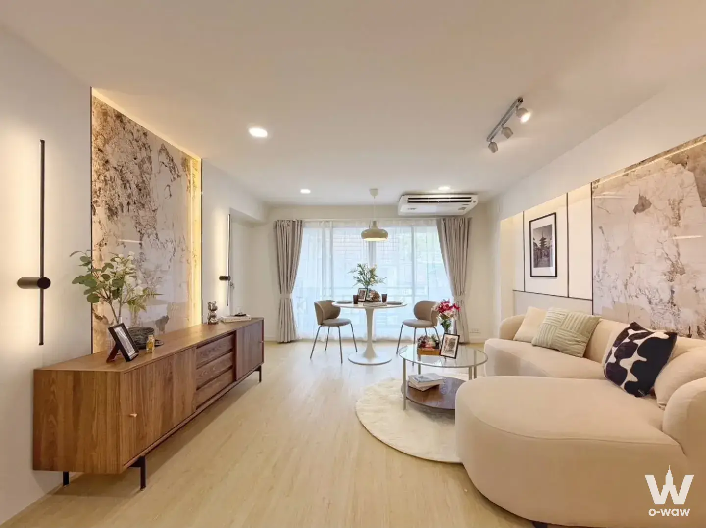 3-bed condo for sale in Bang Na Place Condo with a cream curved sofa and marble feature wall