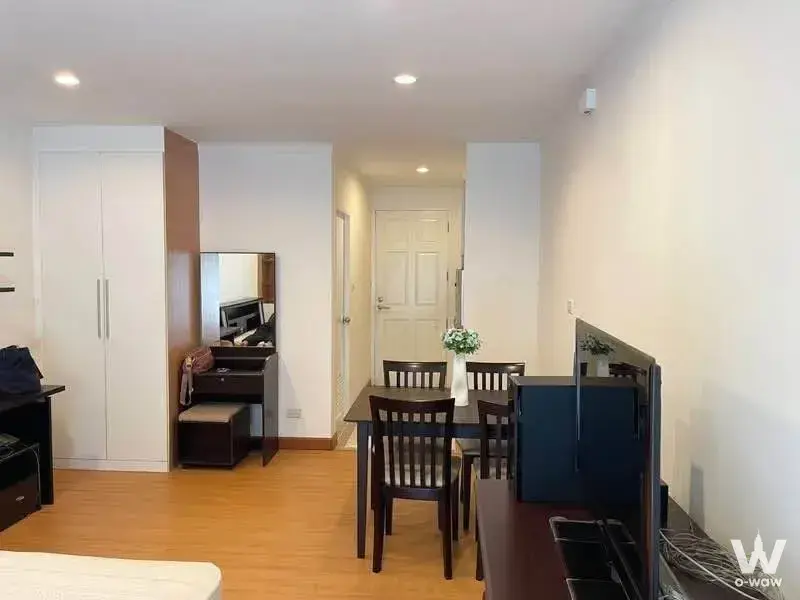 1-bed condo for rent in Baan Siri Sathon with light wood laminate flooring and dark wood vanity desk