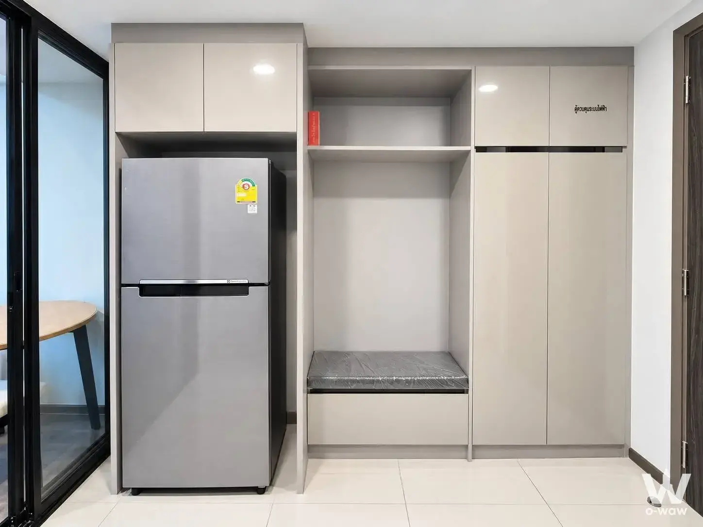 Entryway with beige gloss cabinetry and bench seat in a KnightsBridge Space Rama 9 condo