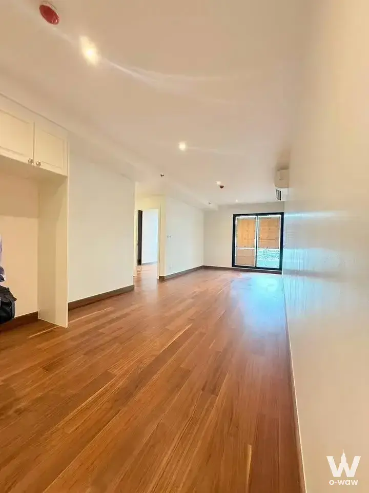 Unfurnished living area with wood floors in Altitude Symphony Charoenkrung