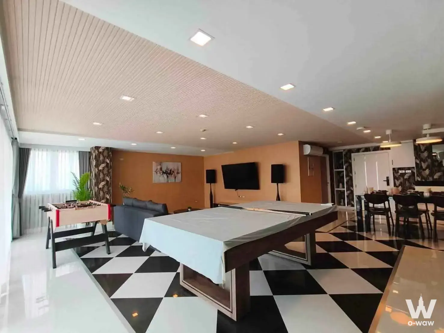 Spacious entertainment room in Regent Phratamnak with a pool table, foosball, and orange accent wall