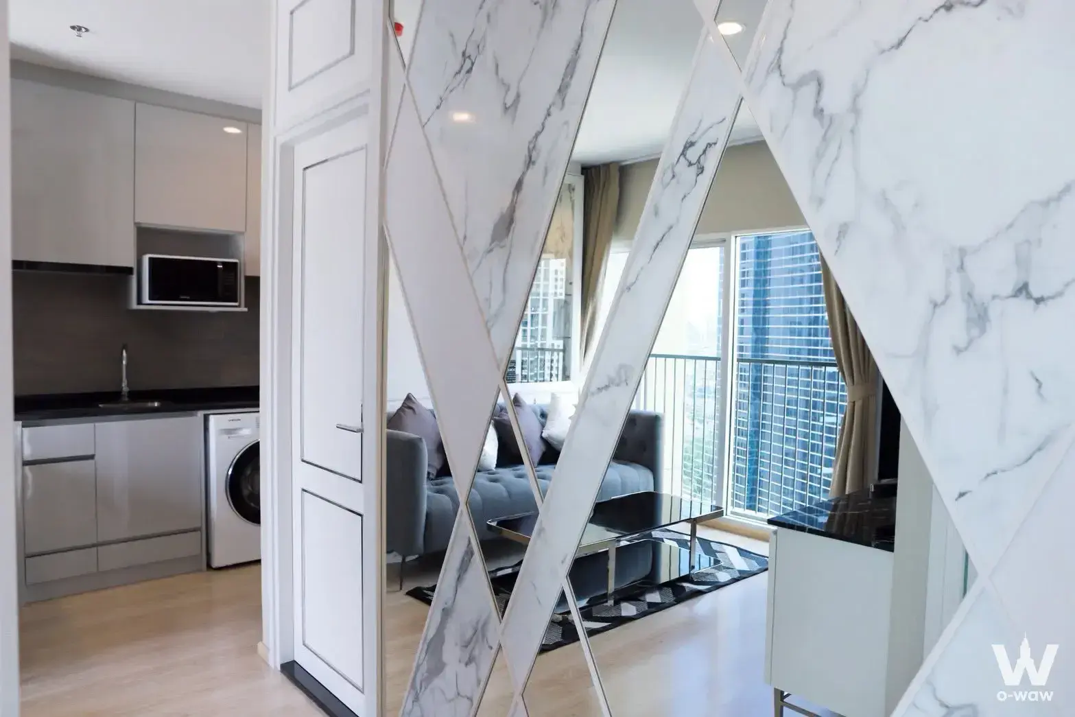 2-bed condo for sale in Noble Revolve Ratchada 2 showcasing a decorative partition wall and city view balcony