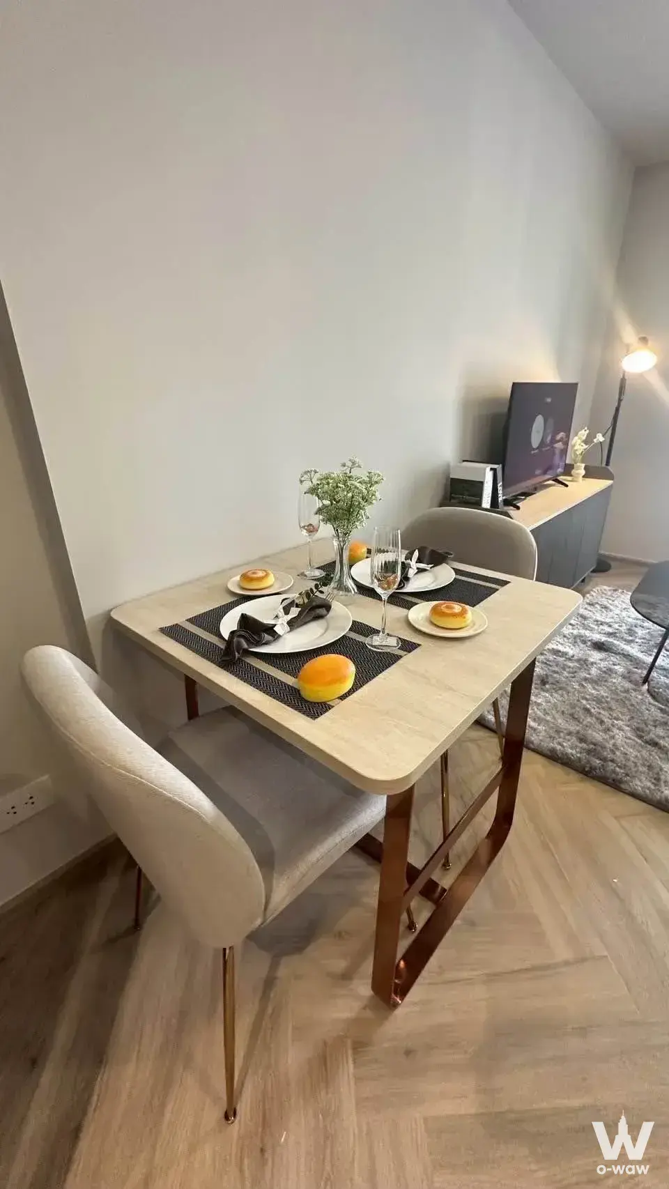 1-bed condo for rent in Chapter Thonglor 25 dining area with light wood table, copper legs, and neutral decor