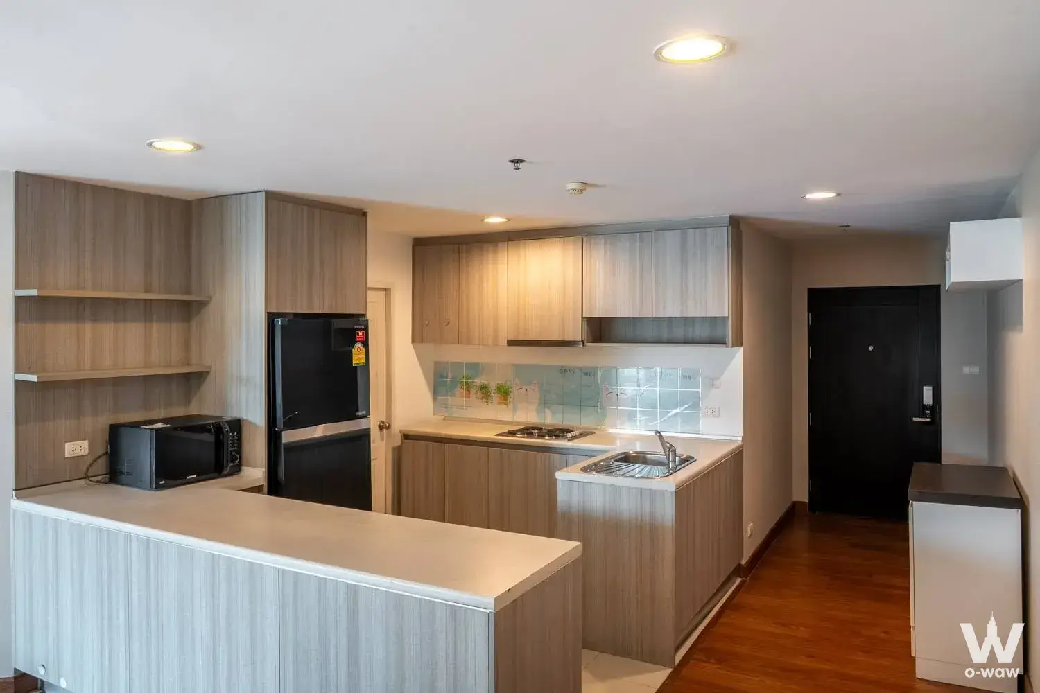 Modern kitchen in Belle Grand Rama 9 condo with quartz counters and floral backsplash