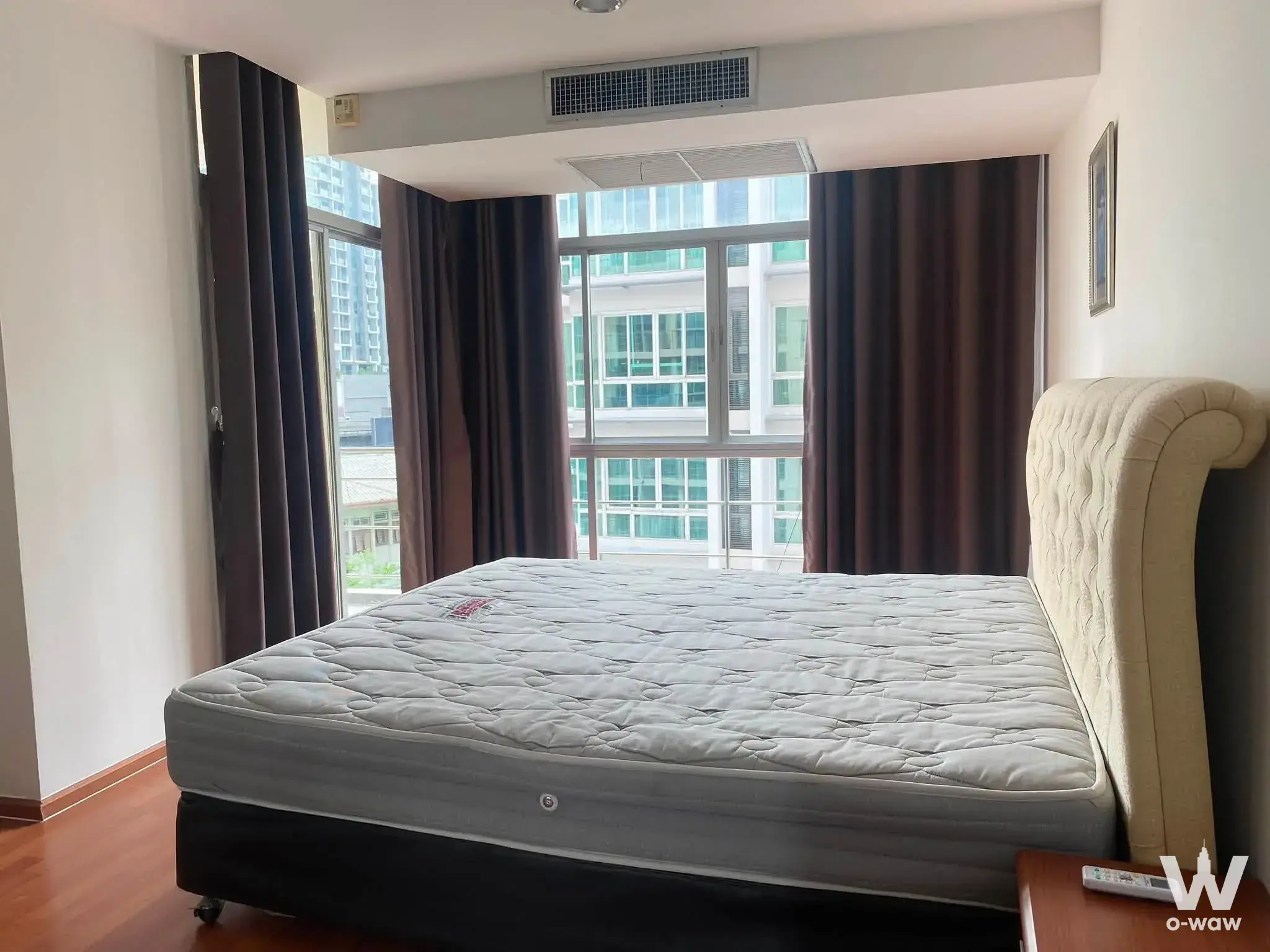 Furnished bedroom in a Waterford Diamond Tower condo featuring a queen bed and large windows with a city view