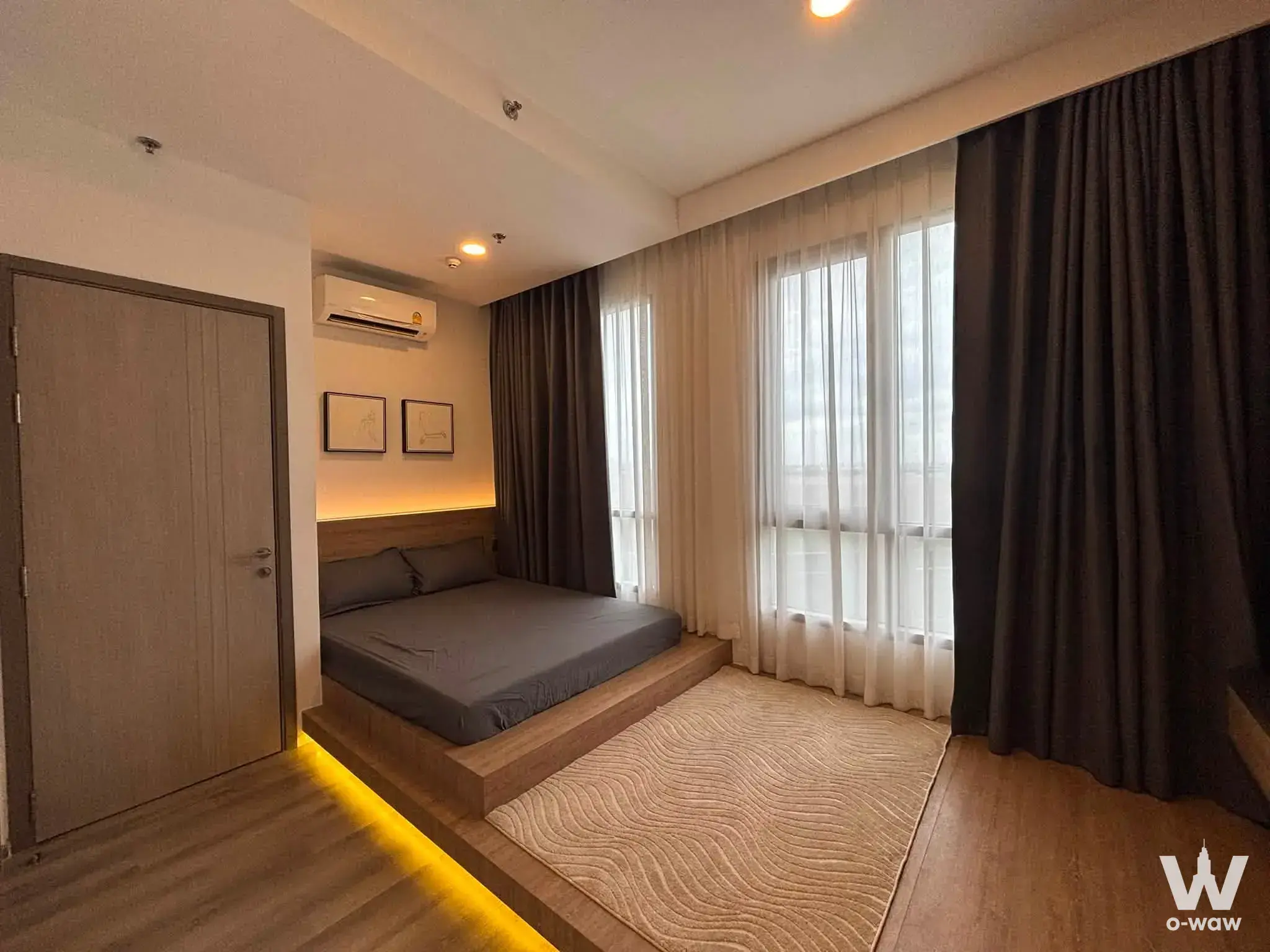 Cozy bedroom with wood platform bed and blackout curtains for sale at Miti Chiva Kaset Station