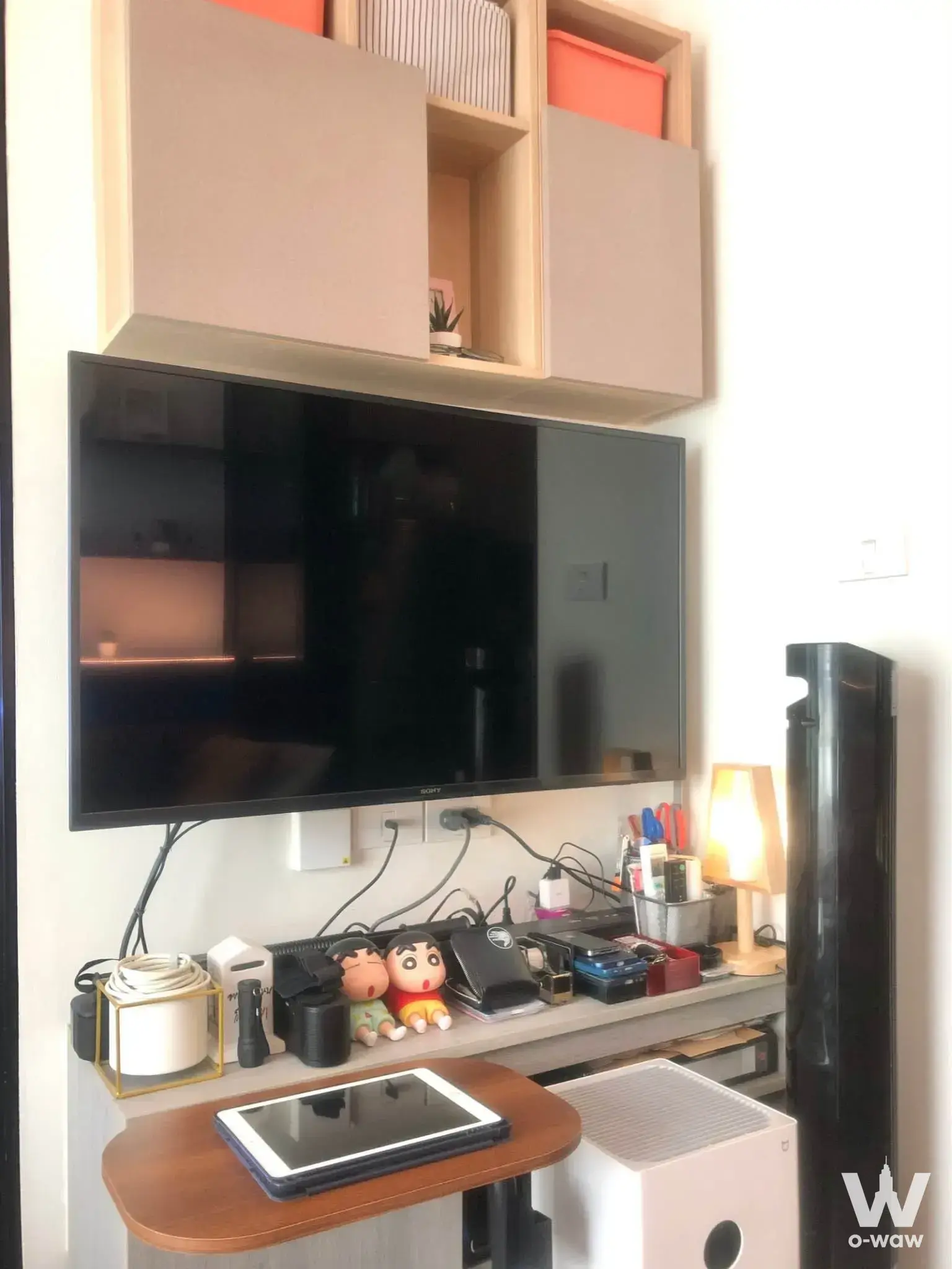 The Origin Onnut one-bed condo for sale featuring cluttered media corner and storage