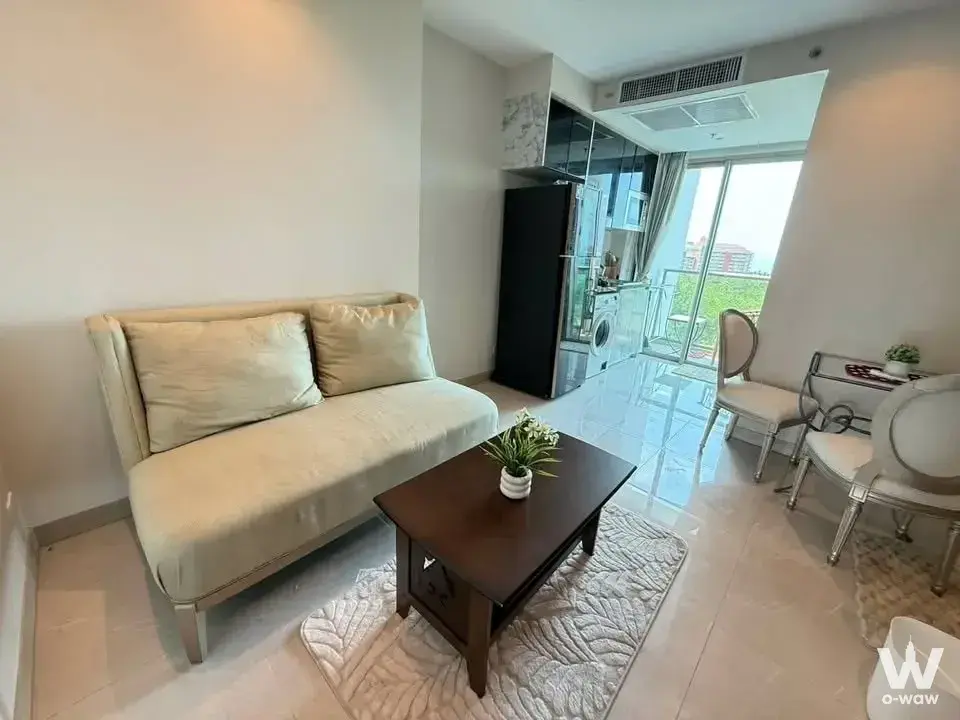 1-bed condo for rent in The Riviera Monaco with cream sofa, dark wood coffee table, and city view
