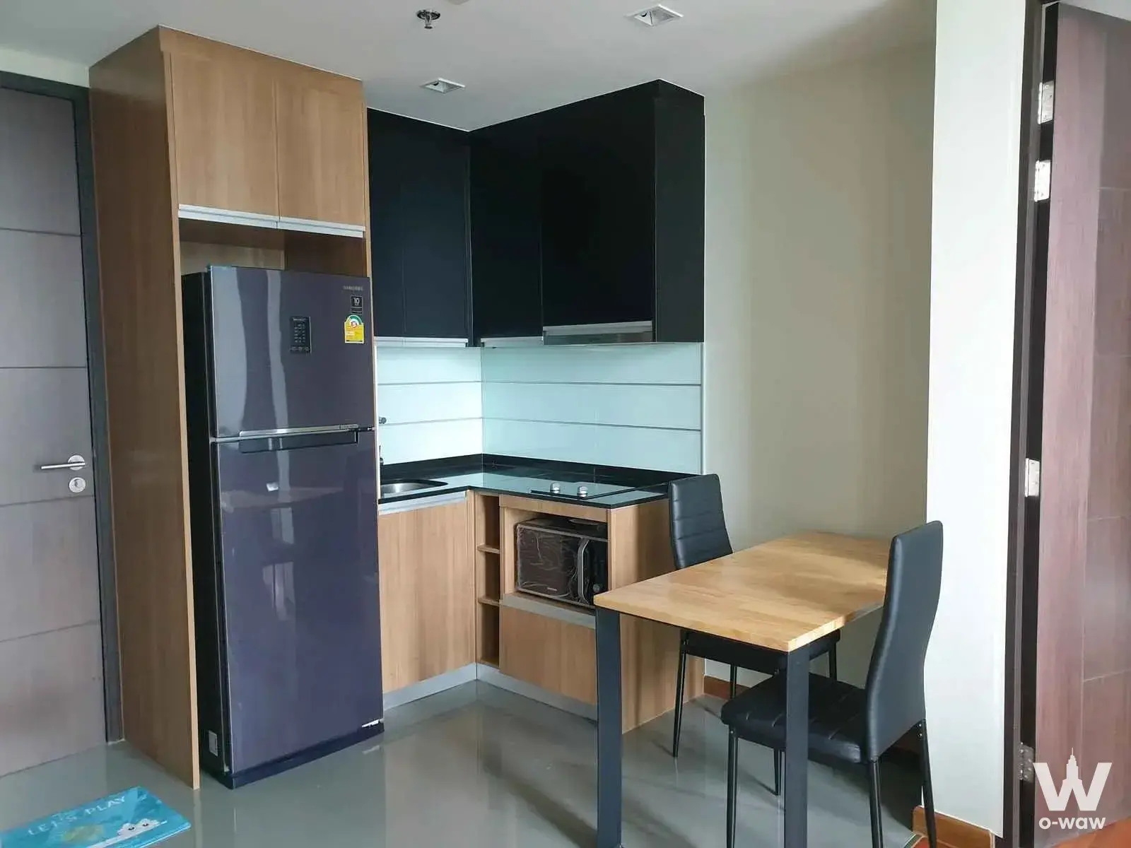 Modern 1-bed condo for rent in WISH Signature Midtown Siam featuring a compact kitchen with black glossy cabinets and a