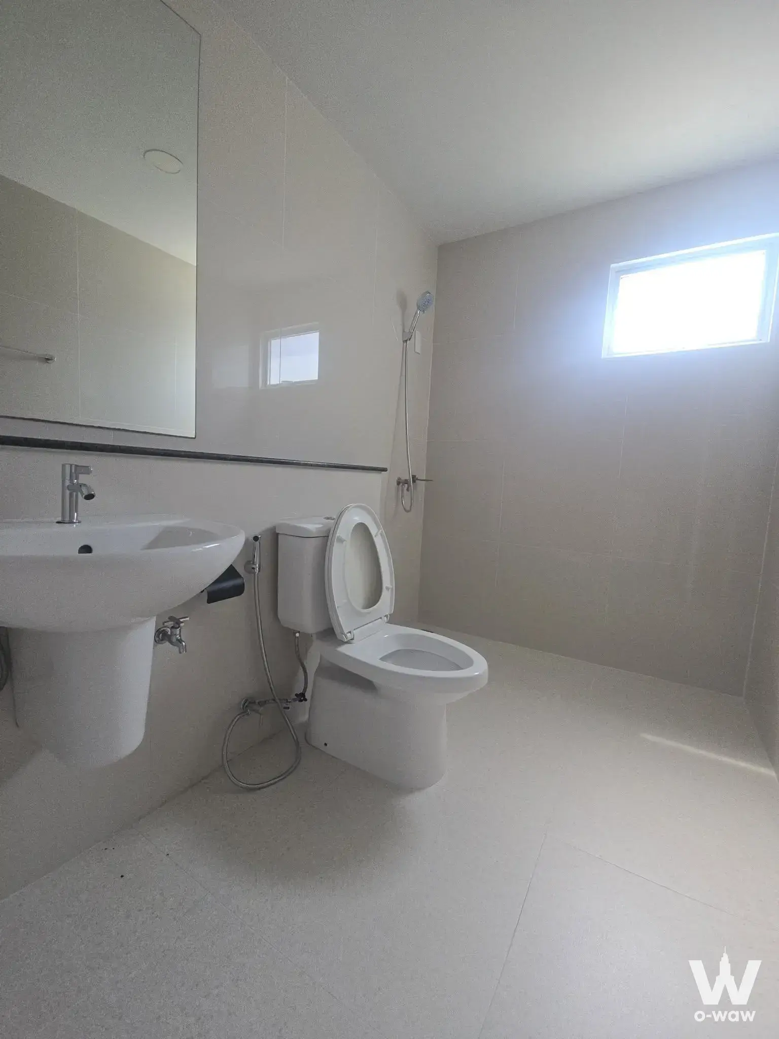 Modern minimalist bathroom with white pedestal sink, frameless mirror, and beige tiles in Modi Villa Bangna