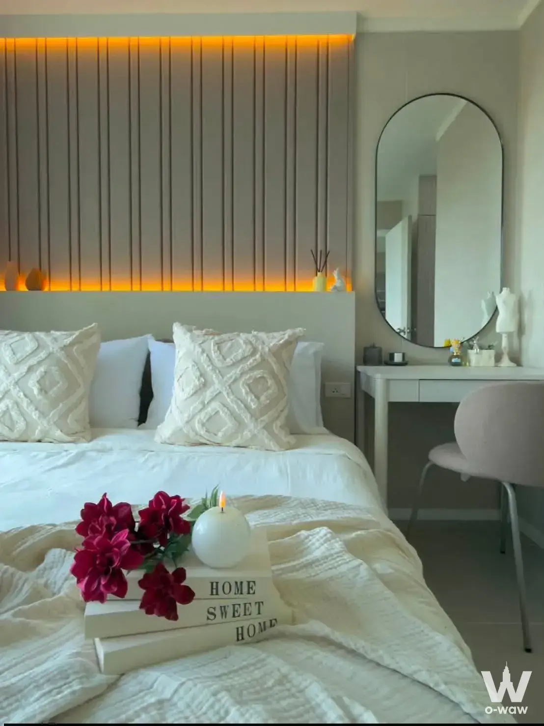 Staged master bedroom in Lumpini Ville Naklua condo for sale with wood slat headboard and amber lighting