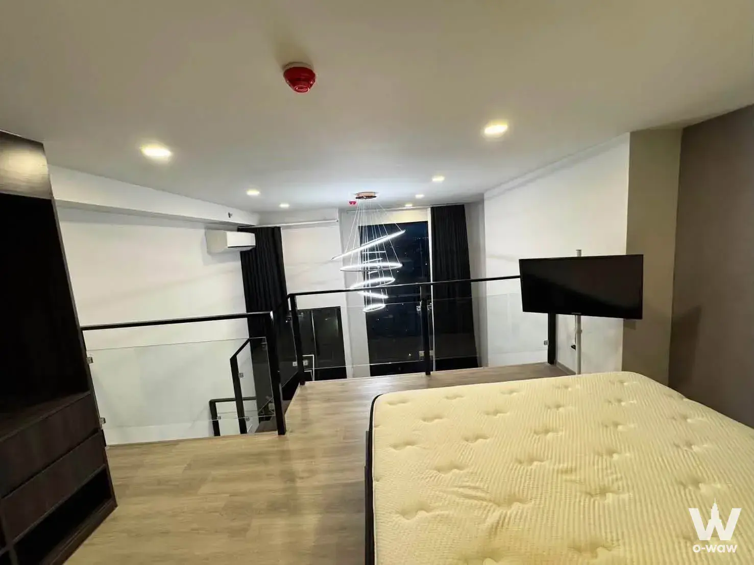 Loft bedroom mezzanine in Origin Plug & Play Ramintra with glass railing and city view