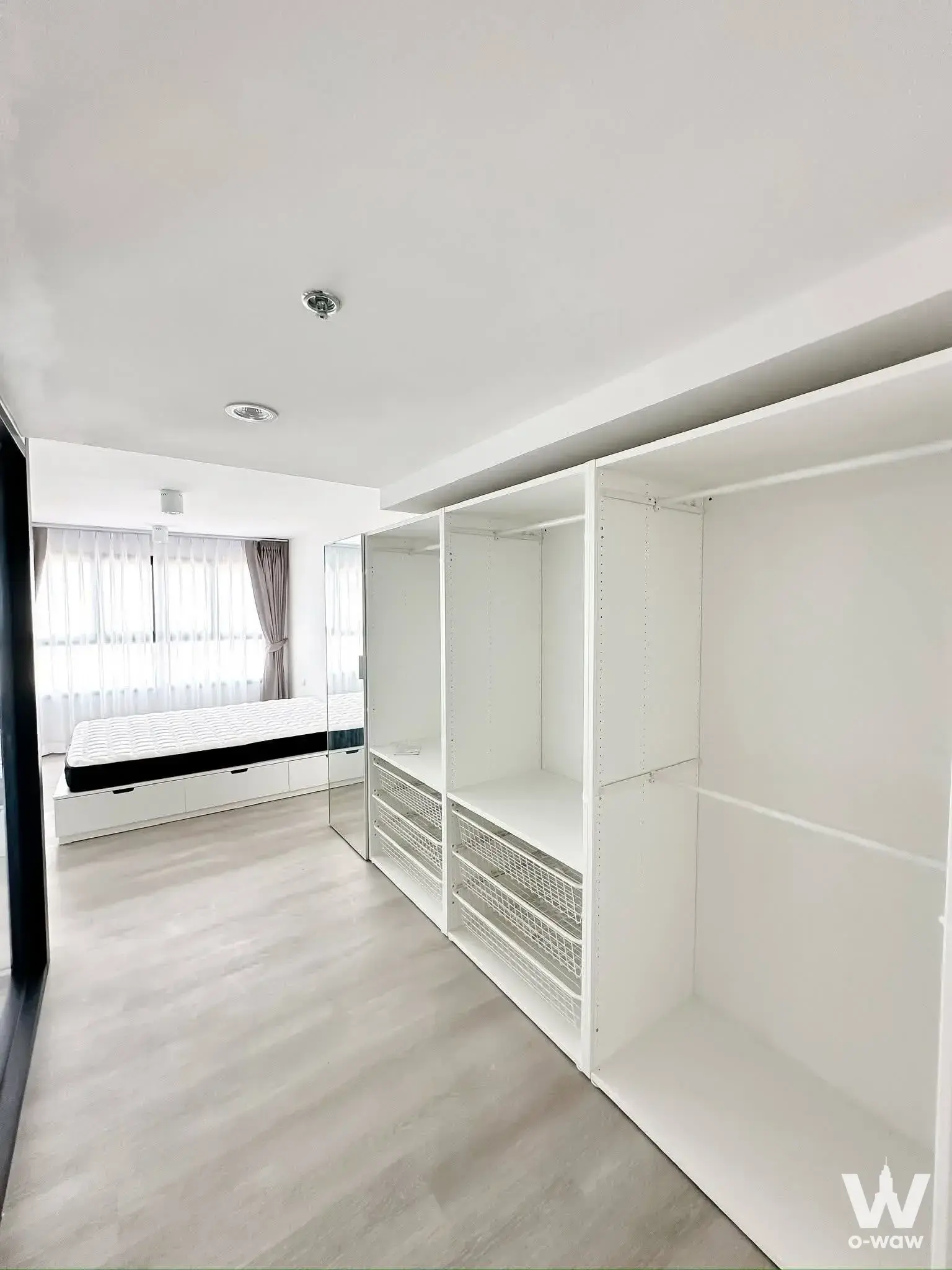 Minimalist bedroom with built-in wardrobe and platform bed in 1-bed condo for rent at Ideo Charan 70