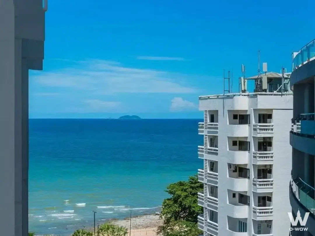 High-floor ocean view with turquoise water and coastal buildings from Sands Condominium