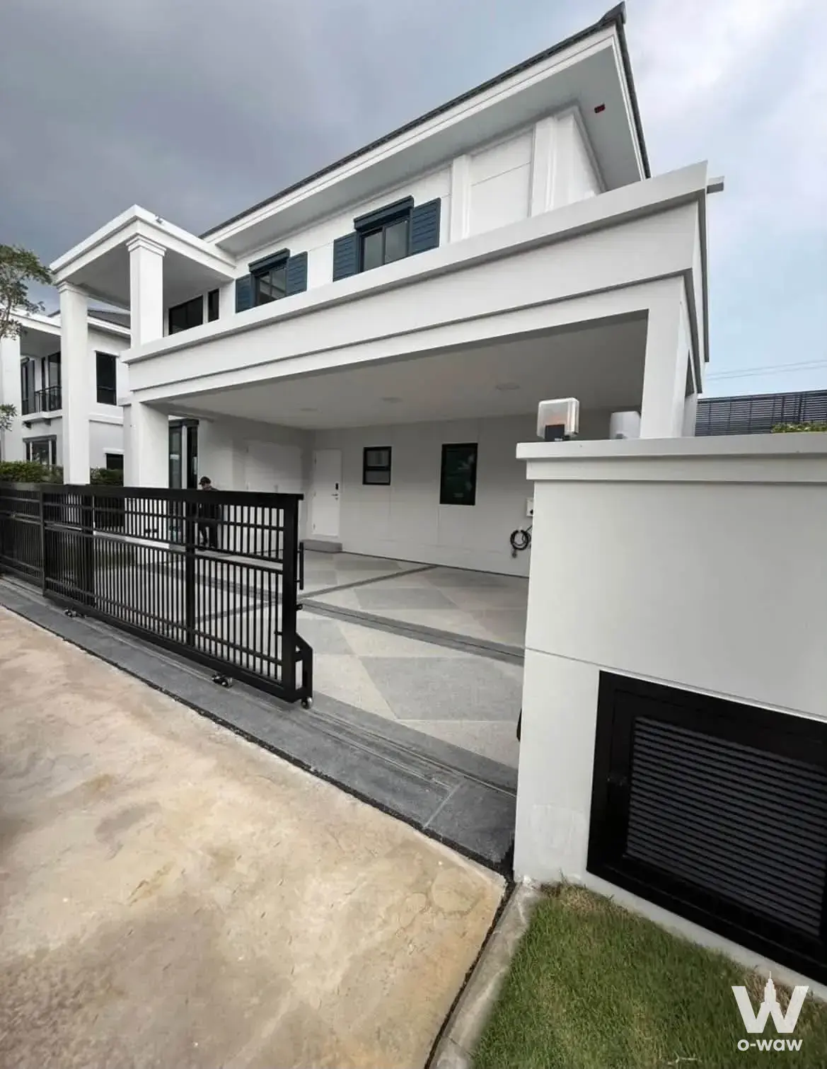 Two-story modern house exterior for rent in Don Mueang with white stucco walls and a covered carport