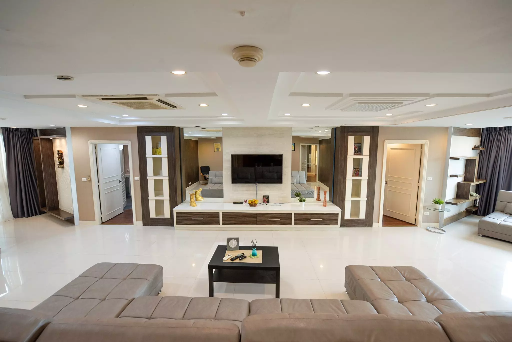 Taupe leather sectional sofa facing a wall-mounted TV in a spacious President Park living room