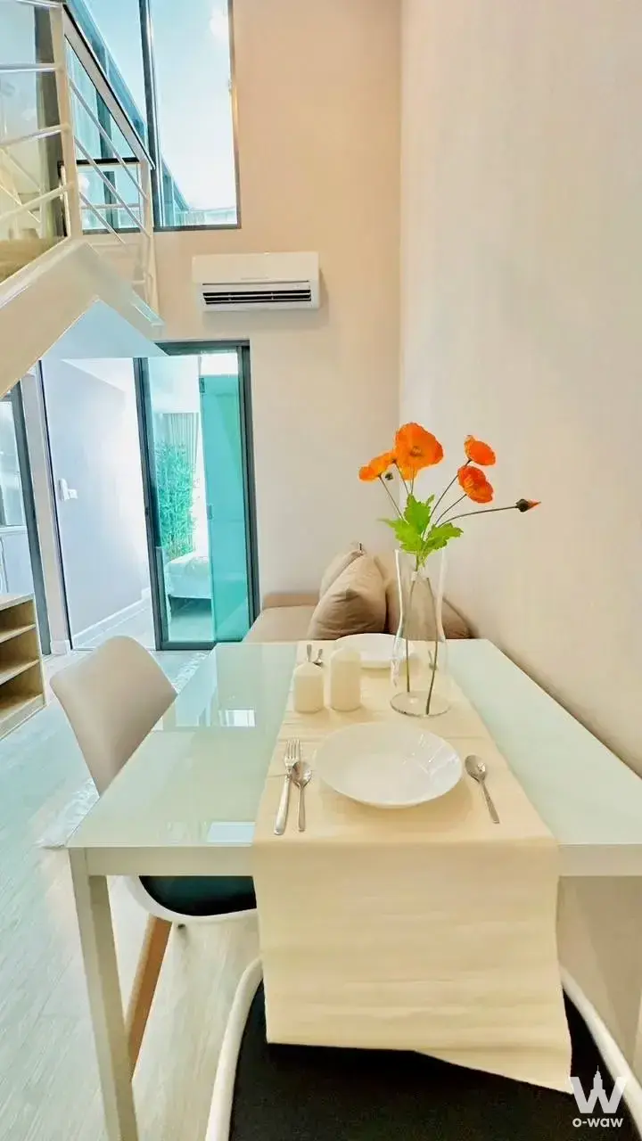 1-bed condo for rent in Metro Sky Prachachuen dining area with loft style, staircase, and orange poppies