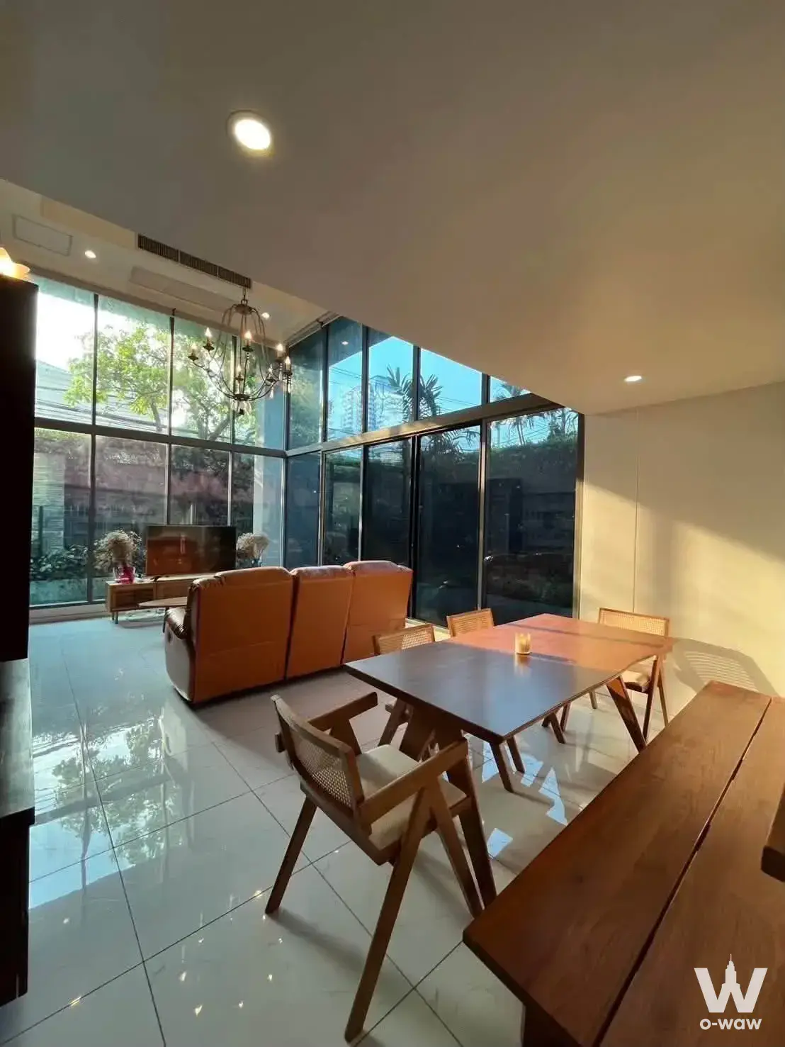 Mid-century modern living and dining area with leather sofa and large windows at Siamese Thirty Nine