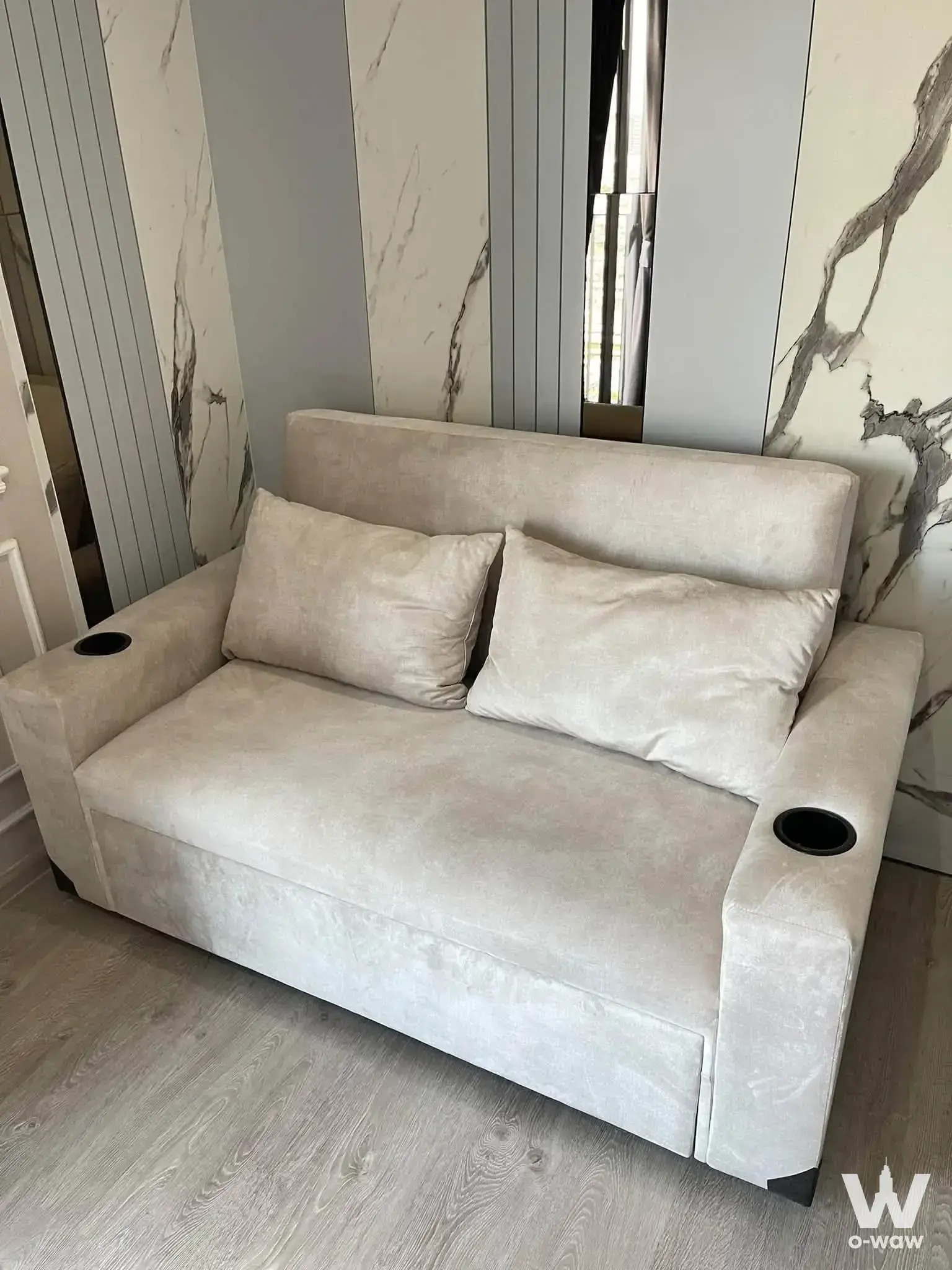 Beige sofa against marble feature wall in an Altitude Unicorn-Tha Phra 1-bed condo