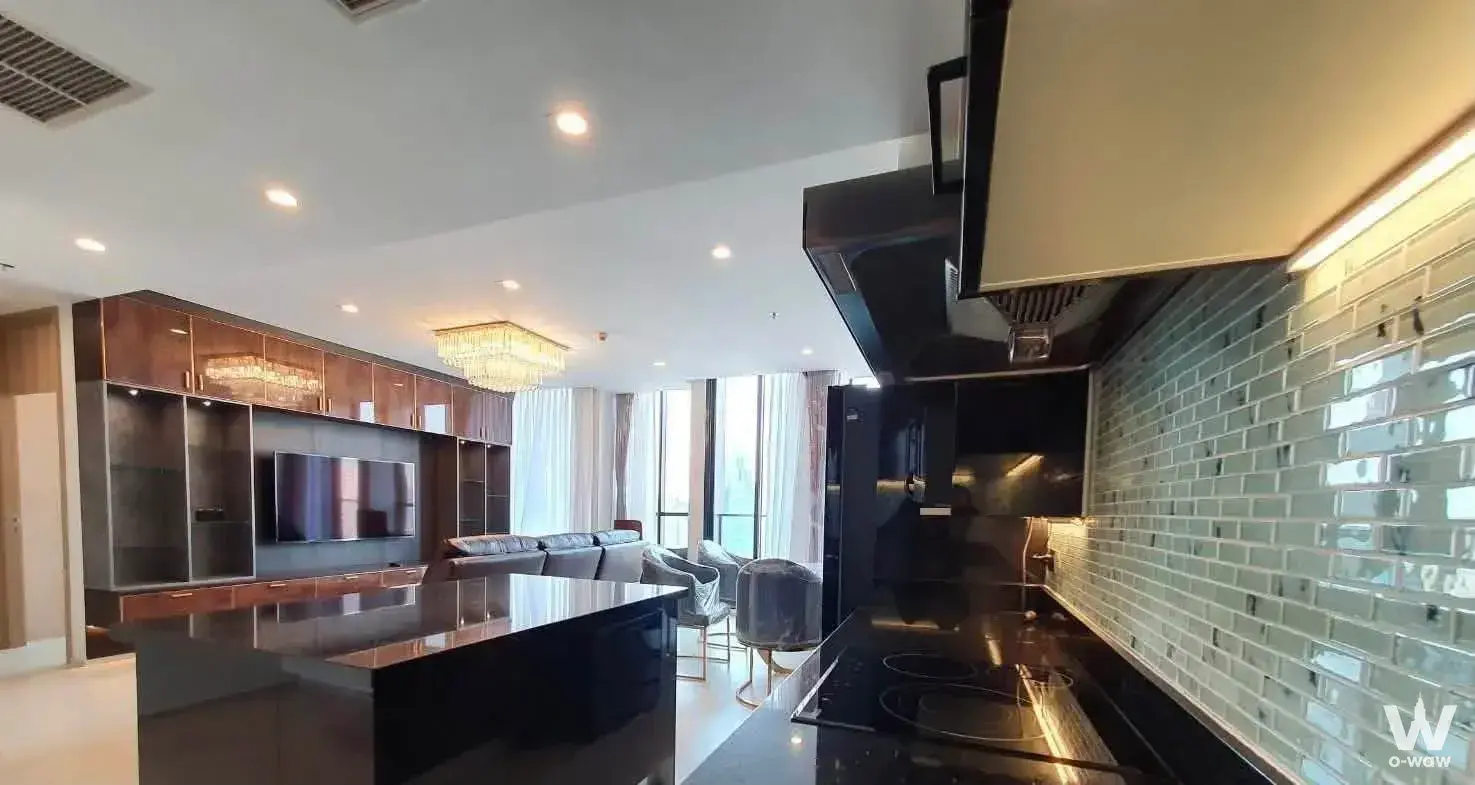 2-bed condo for sale in Noble Ploenchit featuring black granite island, gold armchairs, and bright windows