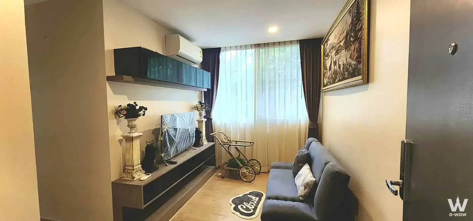 The 2-bed Chateau in Town Charansanitwong 96/2 condo living room has a dark grey sofa and wood media console