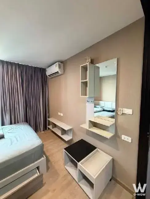 The Cube Urban Sathon 1-bed condo bedroom with white bed frame, taupe accent wall, and integrated vanity