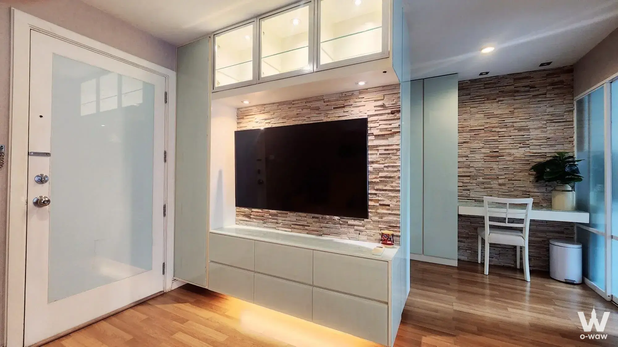 Modern 1-bed condo living room in Lumpini Park Rama 9 with sage green cabinetry and stone accent wall