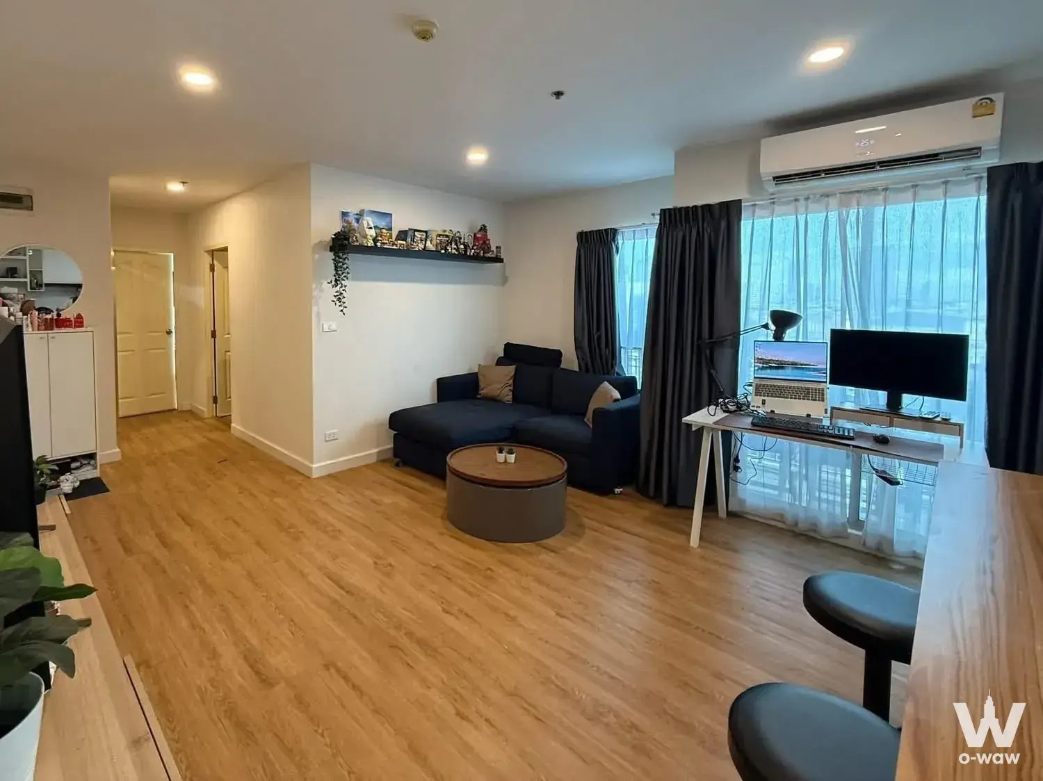 The Niche Taksin 2-bed condo for sale with navy L-shaped sofa, home office desk, and open-plan layout