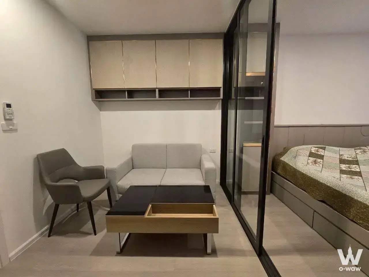 Studio unit with sofa, coffee table, and glass partition separating the bedroom in a CIELA Charan condo