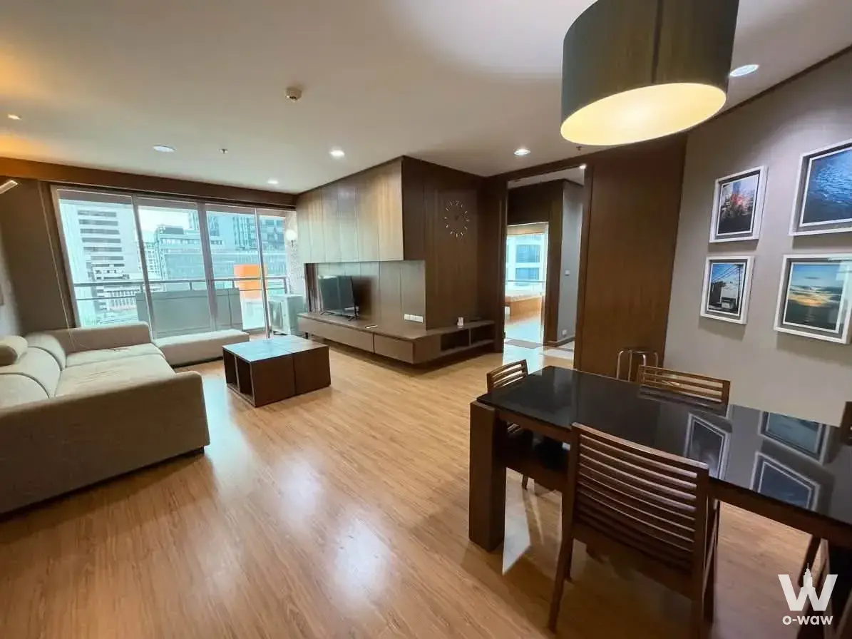 Open plan living area in a Silom Grand Terrace condo with dining set and city views