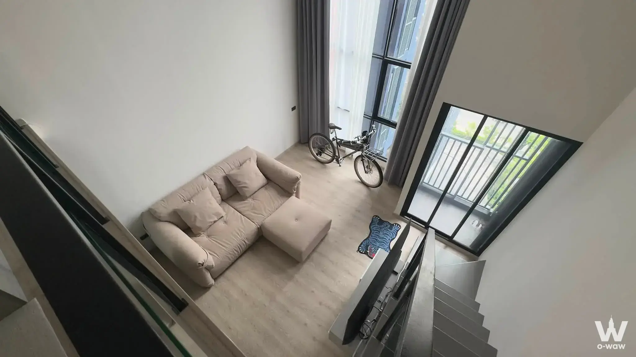Loft living room at Origin Plug & Play Sirindhorn Station with high ceilings and balcony access