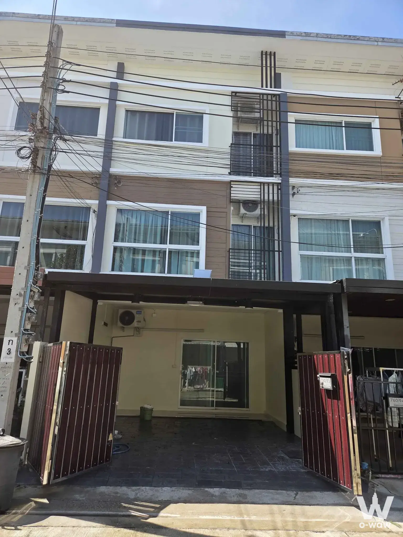 The exterior of this 3-bed Villette City Pattanakarn townhouse shows cream walls, brown siding and maroon gates