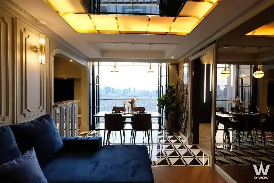 Spacious living-dining area with floor-to-ceiling glass doors offering panoramic Bangkok skyline views